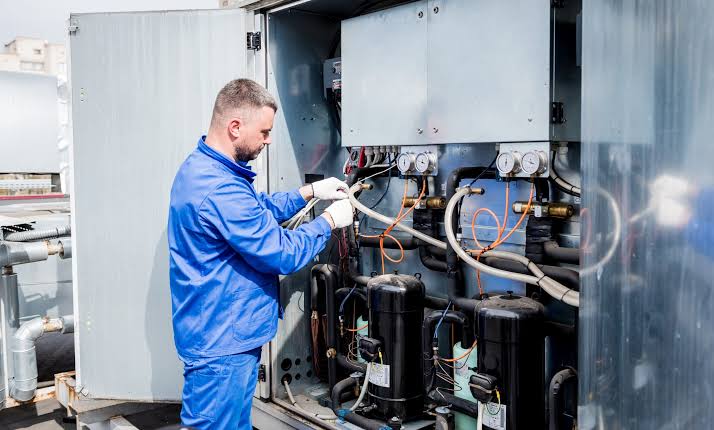 HVAC technician using diagnostic gauges during service