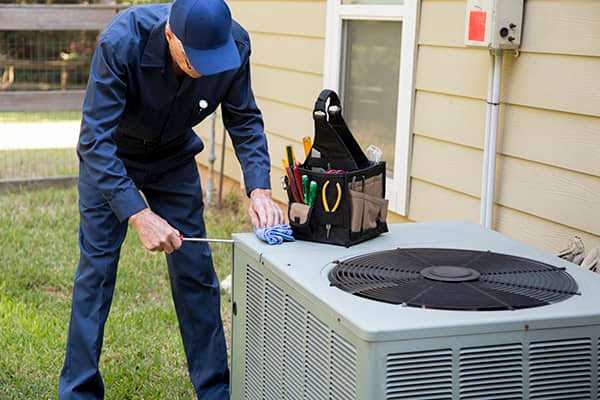 Technician cleaning a wall-mounted residential air conditioning unit