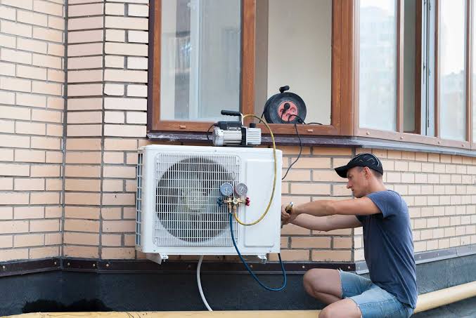 Technician diagnosing an outdoor air conditioning unit