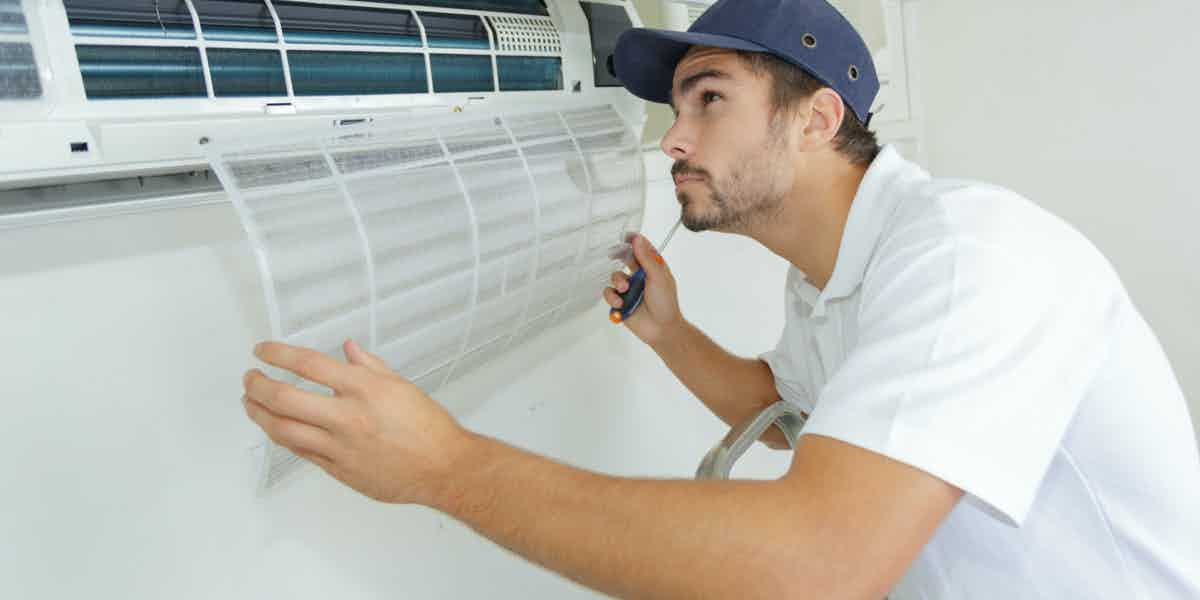 Technician conducting preventive air conditioner maintenance
